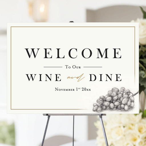 Wine and Dine welcome sign with grape illustration and customizable text, displayed on an easel for party or event decoration.