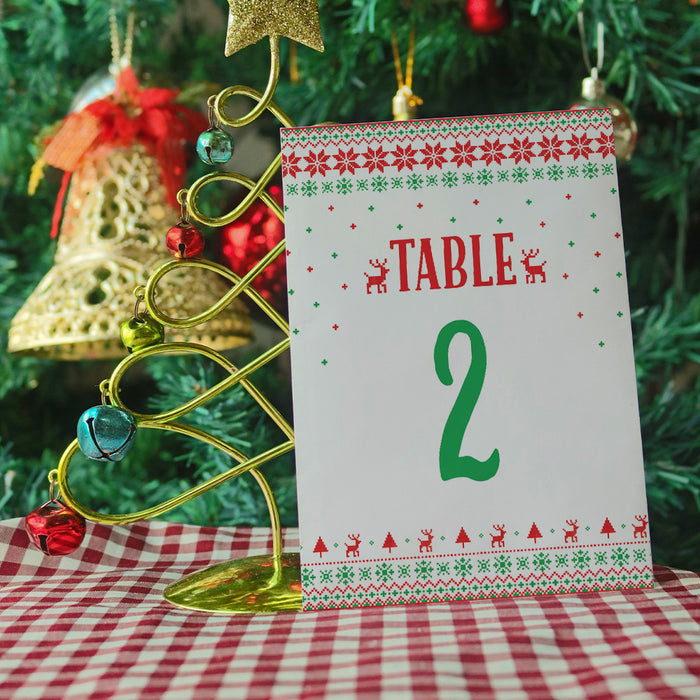 Christmas-themed table number card with decorative stand against a festive background
