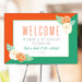 Floral birthday welcome sign with an orange and green border, and watercolor peony flowers for party and venue décor.