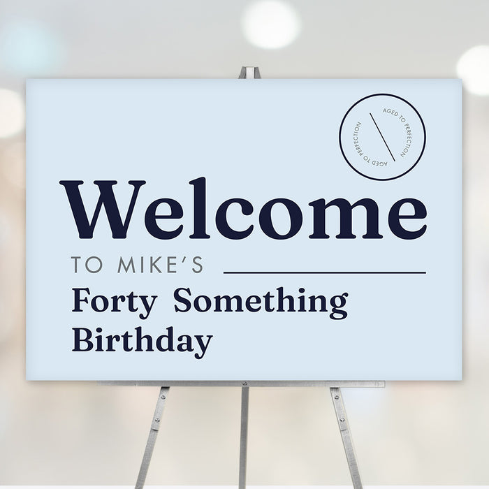 Funny forty something birthday welcome sign in light blue with navy text and aged to perfection badge, displayed on an easel for milestone party décor.
