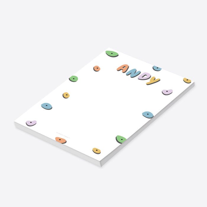 Personalized kids notepad with colorful rock climbing hold design on black background-side