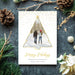 Elegant holiday photo card featuring a gold-outlined Christmas tree photo frame, gold confetti accents and modern script Happy Holidays typography on a white background.