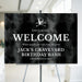 gothic birthday welcome sign with a black watercolor background, skull-and-crossbones illustration, custom birthday wording for a spooky party entrance.
