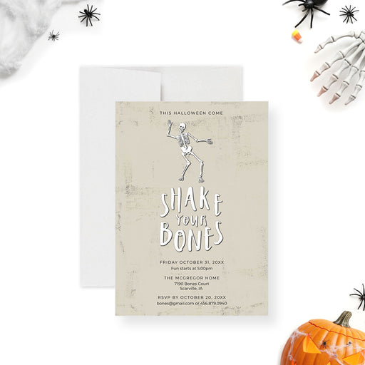 Halloween invitation featuring a dancing skeleton, the phrase "Shake Your Bones," and event details-front
