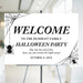 Halloween party welcome sign featuring spider web corners and hanging spiders with a clean black and white elegant design