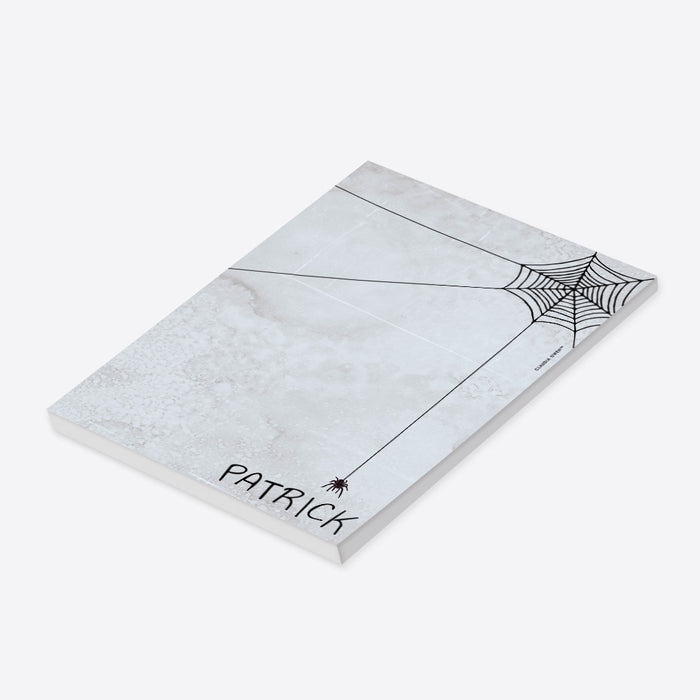 personalized Halloween notepad with spooky spider web design, gray textured background, hanging spider, and custom name-side