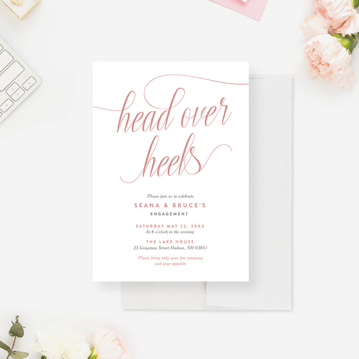 Romantic engagement invitation featuring “head over heels” in blush pink script with elegant minimalist layout-front