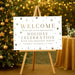 holiday party welcome sign with gold seasonal accents, snowflakes, acorns, and custom Christmas celebration wording displayed on an easel