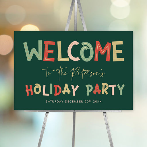 Festive green holiday party welcome sign with colorful block lettering, displayed on an easel.