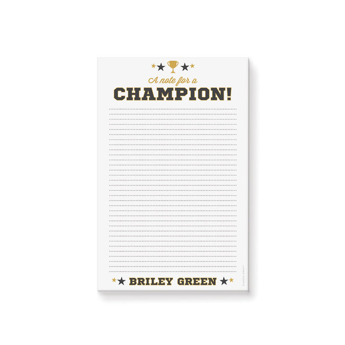 Personalized notepad featuring a trophy, varsity-style lettering, "A note for a champion!" text, and a customizable name