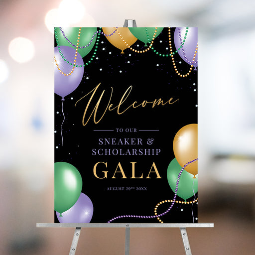 Mardi Gras gala welcome sign featuring balloons, beads, and gold lettering on a black background.