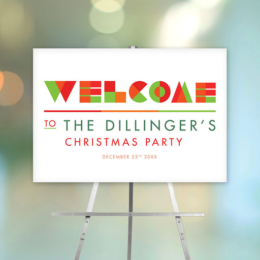Christmas party welcome sign featuring modern typography in red, green, and orange, displayed on an easel.