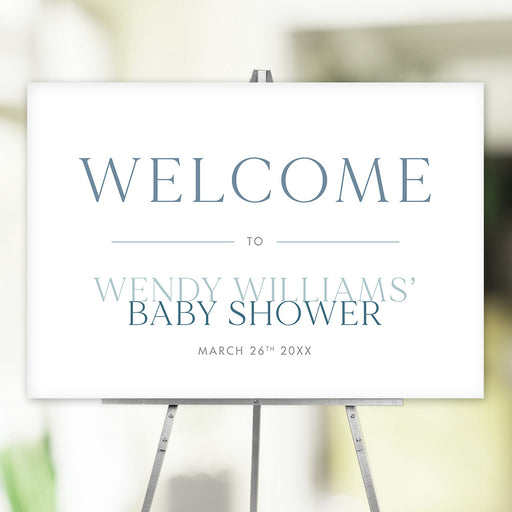 Minimalist blue baby shower welcome sign customized with event name and date, displayed on an easel.