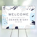 modern personalized birthday welcome sign with abstract blue and gray brushstroke artwork and minimalist typography on easel display.
