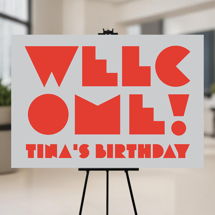 modern birthday party welcome sign with bold red lettering, gray background, and personalized birthday party wording displayed on an easel