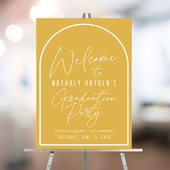 Class of 2026 graduation welcome sign in mustard yellow with modern script lettering, personalized graduate name, and party date displayed on an easel.