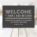 Modern personalized Bar Mitzvah welcome sign with gray background, custom name and event date displayed on an easel