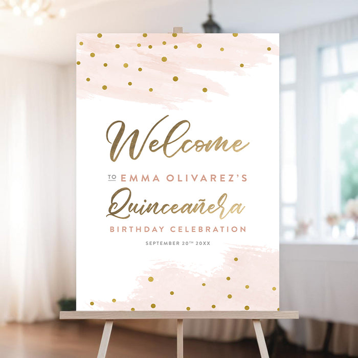 Pink and gold quinceañera welcome sign with watercolor accents and gold confetti displayed on an easel for a Sweet 15 celebration.