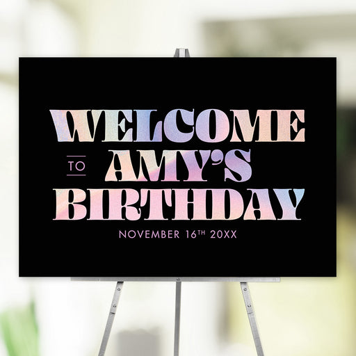Surprise birthday welcome sign with colorful pastel typography on black background, personalized party décor for celebrations.