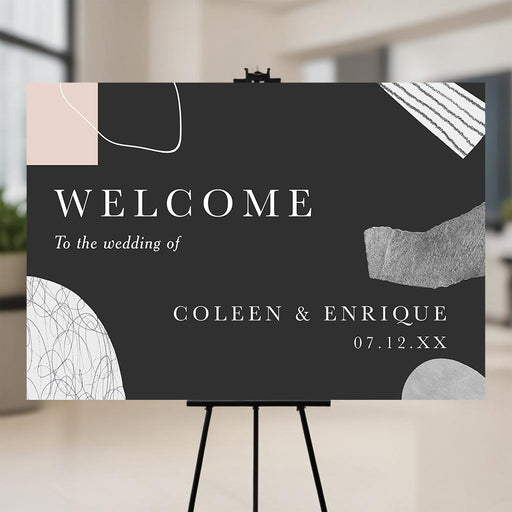 Modern abstract wedding welcome sign with black background and minimalist shapes displayed on easel.