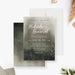 moody botanical wedding invitation with soft watercolor background, white script lettering, and delicate foliage details along the bottom-front-back