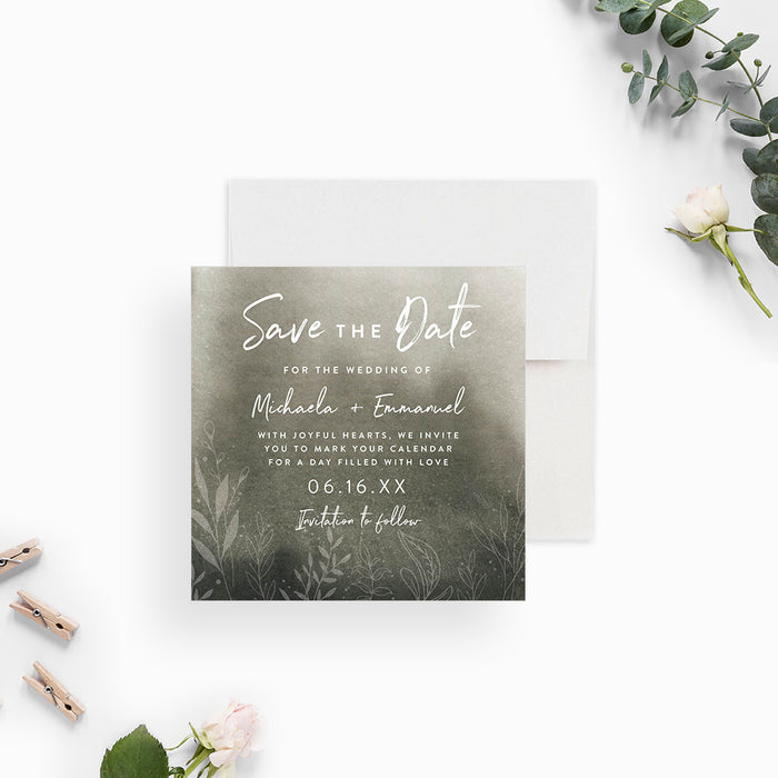 moody green botanical wedding save the date card with soft watercolor background, white lettering, and delicate foliage details-front