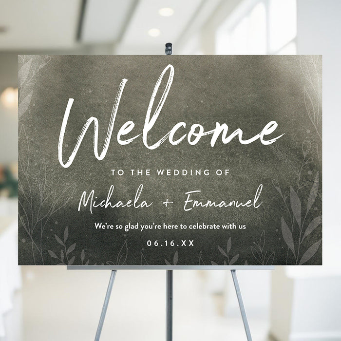 botanical wedding welcome sign with moody green background, white lettering, delicate foliage artwork, and personalized couple names
