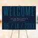 Modern Bar Mitzvah welcome sign with navy background and teal typography displayed on easel for Jewish event entrance décor