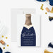 navy champagne bottle graduation party invitation with elegant script lettering, gold-colored accent details, tassels, and personalized event wording-front