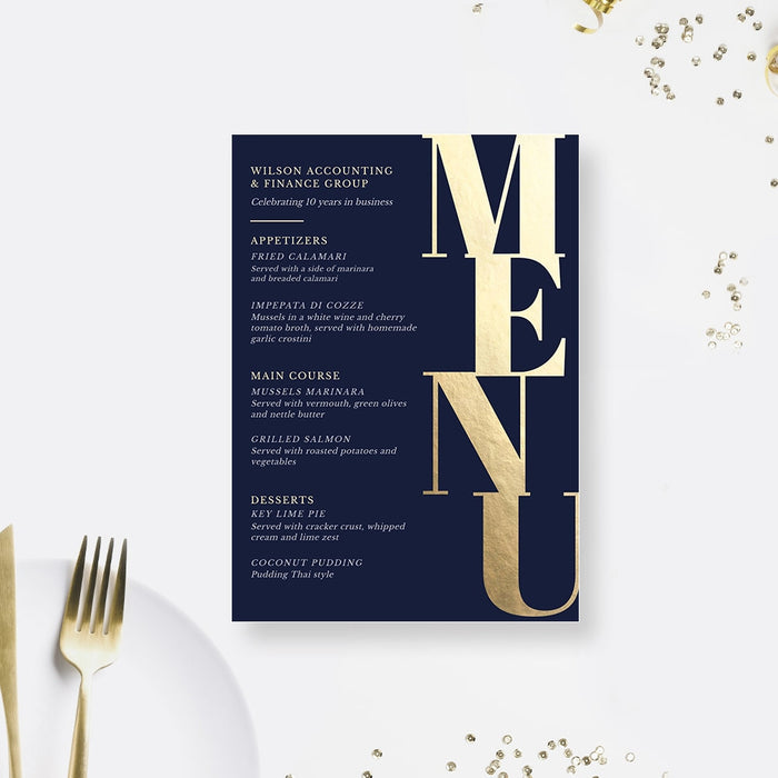 Navy blue dinner menu with oversized vertical gold Menu lettering, shown beside a gold fork.