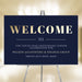 Navy blue welcome sign with a gold Welcome heading, displayed on an easel.