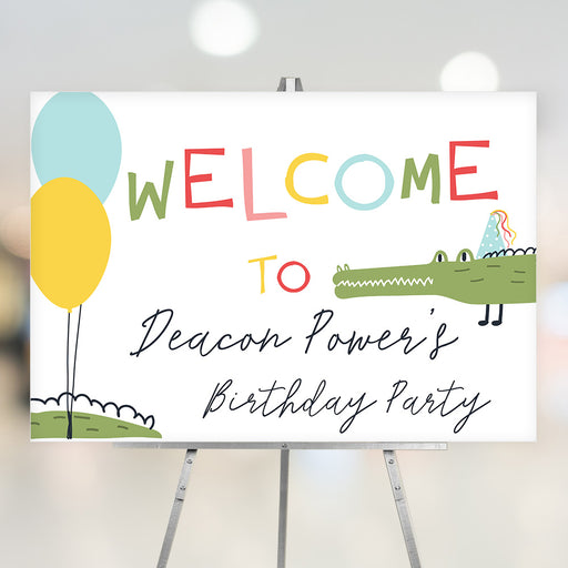 Kids birthday welcome sign with colorful lettering, cute alligator in a party hat, and balloons on a playful gator party design.