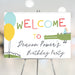 Kids birthday welcome sign with colorful lettering, cute alligator in a party hat, and balloons on a playful gator party design.