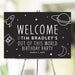 "Out of This World" birthday welcome sign with a rocket ship, planets, and stars design