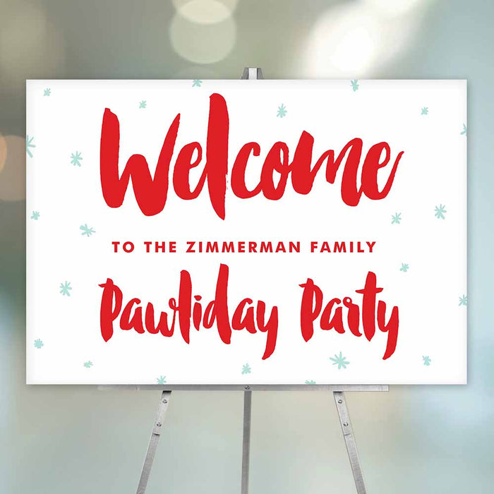 Festive red and white welcome sign for a Pawliday party, personalized with the family name and decorated with light blue snowflakes.
