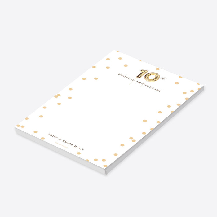 Personalized notepad with gold confetti dots, gold balloon 10th anniversary design, and custom names at the bottom-side
