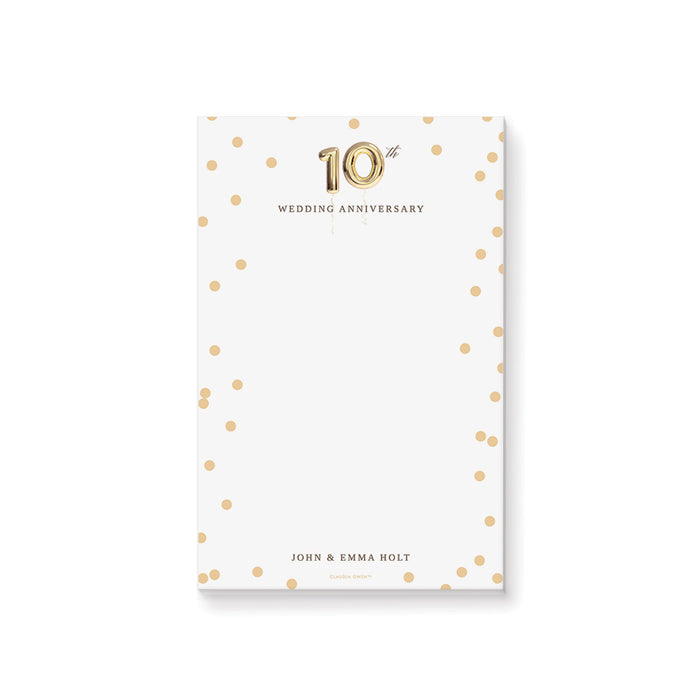 Personalized notepad with gold confetti dots, gold balloon 10th anniversary design, and custom names at the bottom