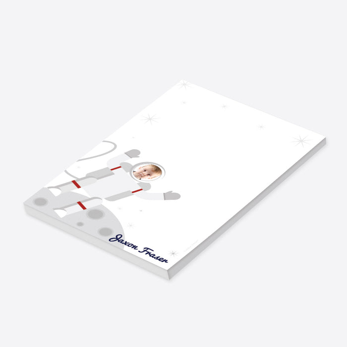 Personalized astronaut photo notepad for kids with child’s face in an illustrated spacesuit, custom name, moon landscape and blank writing area-side