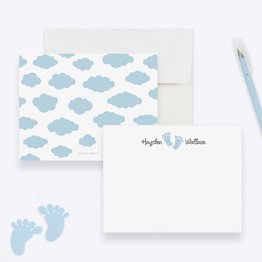Personalized baby note cards with blue footprints between the first and last name on white and a blue cloud pattern on the back.