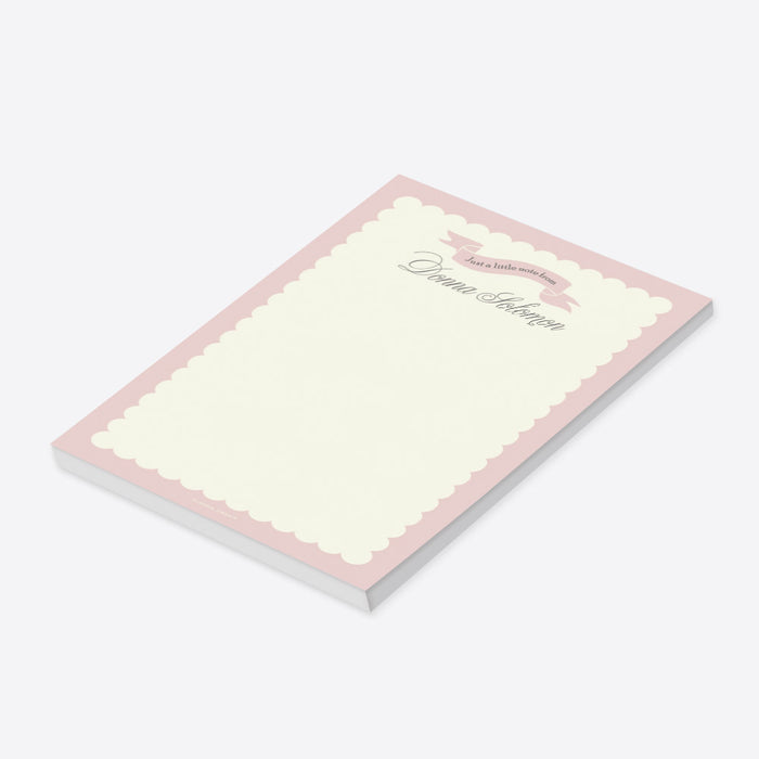 Blush pink custom notepad with pastel cream border and ribbon banner, featuring a personalized name for stationery gift or party favor.-side