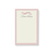 Blush pink custom notepad with pastel cream border and ribbon banner, featuring a personalized name for stationery gift or party favor.