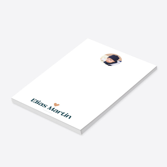Personalized white baby photo notepad with a circular portrait, peach heart and child’s name in teal lettering-side