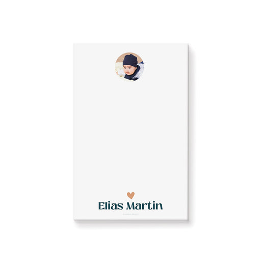 Personalized white baby photo notepad with a circular portrait, peach heart and child’s name in teal lettering