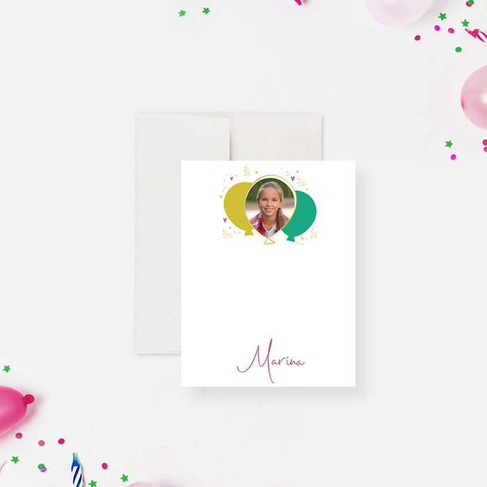 White personalized birthday note card with a child's photo inside a colorful balloon design and a script name below.