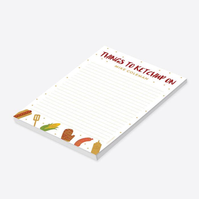 Personalized lined BBQ notepad with Things to Ketchup On heading, custom name, hot dog, corn, sausage, grill mitt, spatula and mustard illustrations-side
