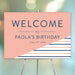 Personalized birthday party welcome sign with peach background, navy blue and peach stripes, honoree’s name and celebration date