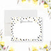 Personalized note card with a white front framed by scattered black and printed gold leaves with a personalized name. Shown with a white envelope.