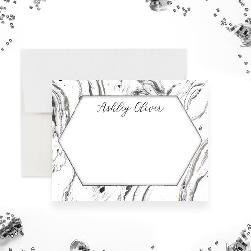 Personalized note card with a black and white marble front with a white hexagonal writing area and a name in script. Shown with a white envelope.