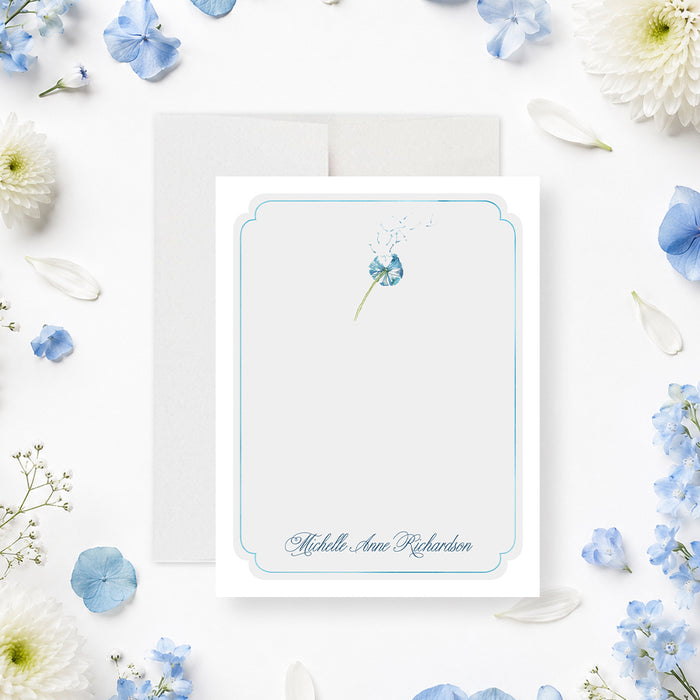 Personalized blue floral memorial thank you card with delicate dandelion flower, pale blue border, and custom name-front