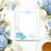 Personalized blue floral tea party note card with teacup illustration, botanical border, and custom name-front